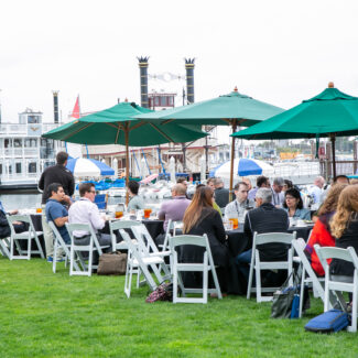 attendees sitting at tables outside