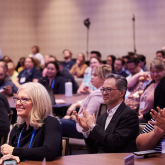 session attendees smiling and clapping